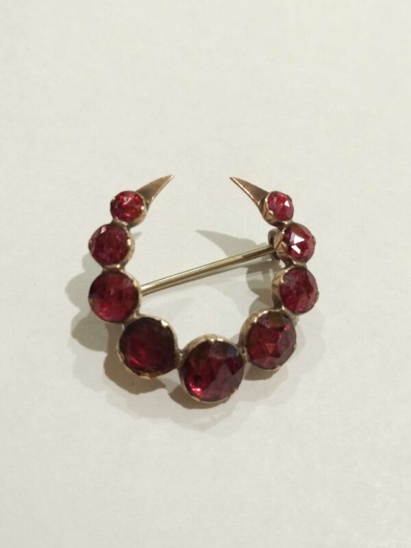 Broche con forma de luna en oro de 18k y granates. Circa: 1900-1910.