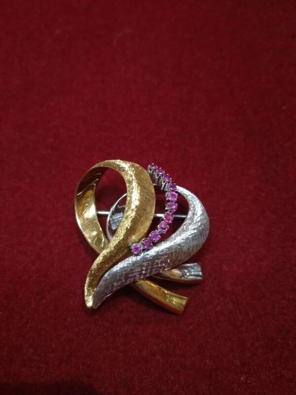 Broche de oro bicolor de 18k (750 mm) con once rubíes. Circa: 1970.