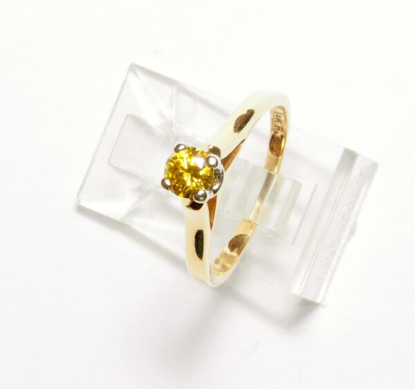 Solitario en oro de 18k con brillante fancy amarillo y garras en oro blanco. Moderno.